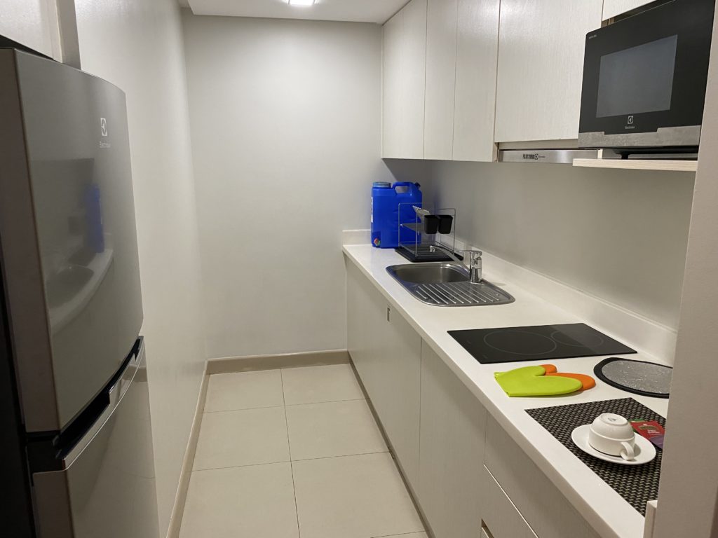 Modern white kitchen with clean countertops and appliances.