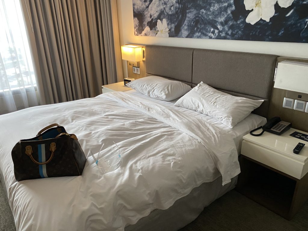 Cozy hotel room with a neatly made bed and soft lighting.