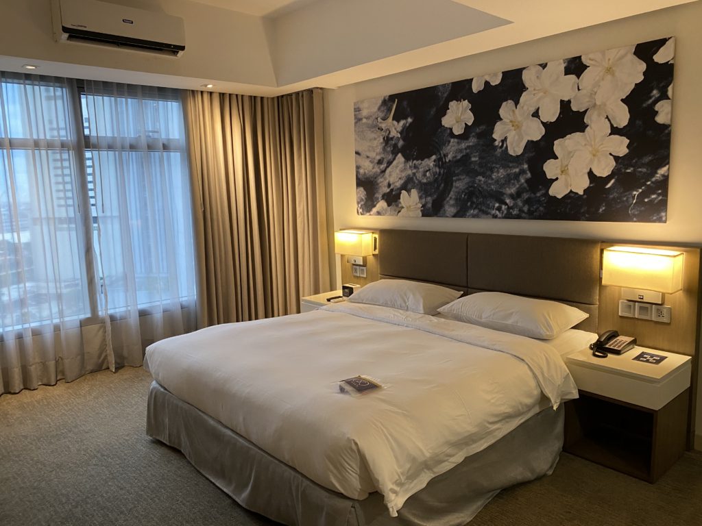 Cozy hotel room with a large bed and floral wall art.