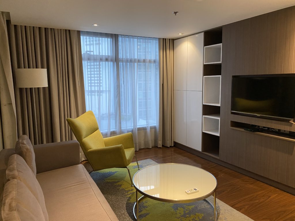 Modern living room with yellow armchair and round coffee table.