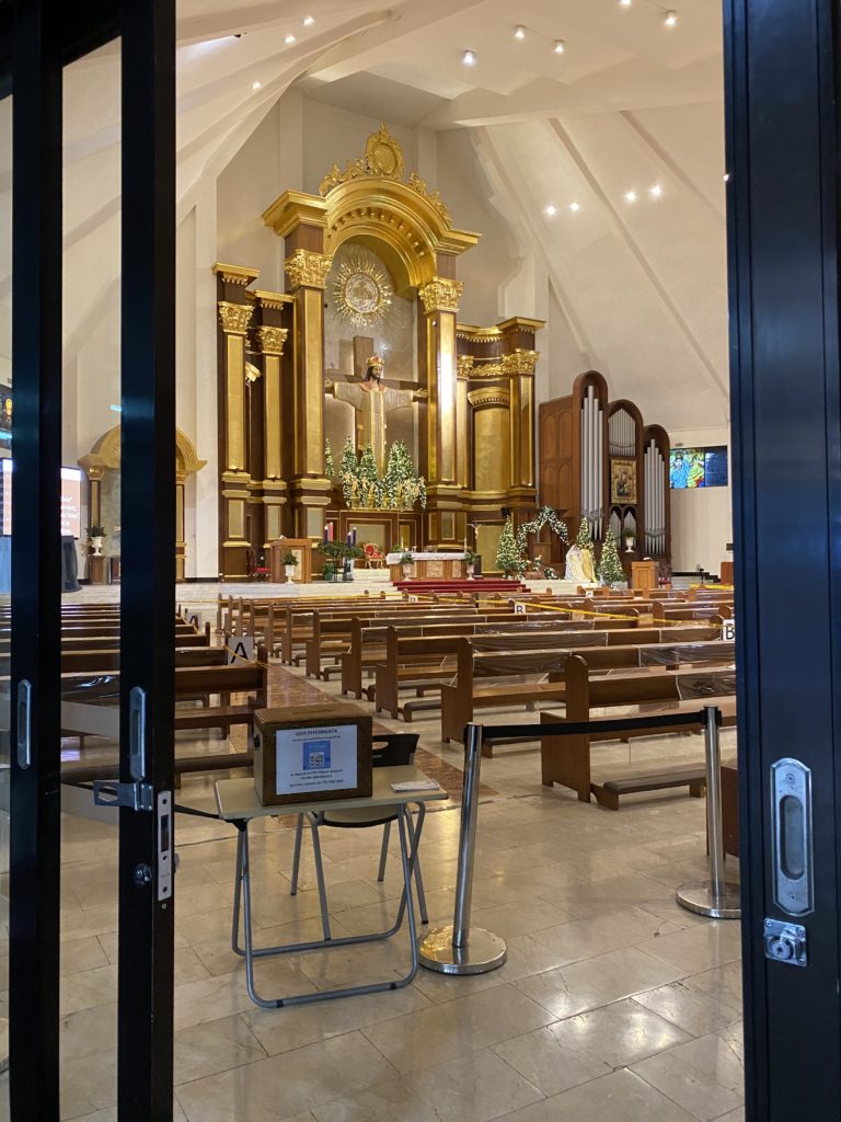 Inside view of a beautifully decorated chapel with golden altar and wooden pews.