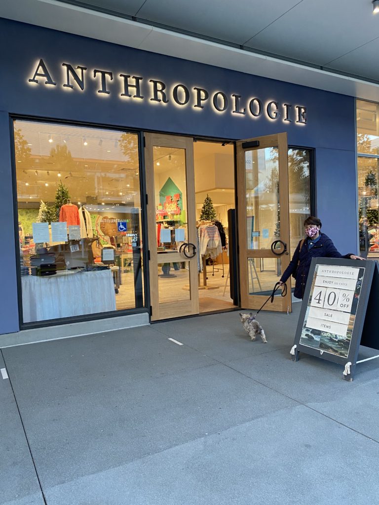 Storefront of Anthropologie with a person walking by.