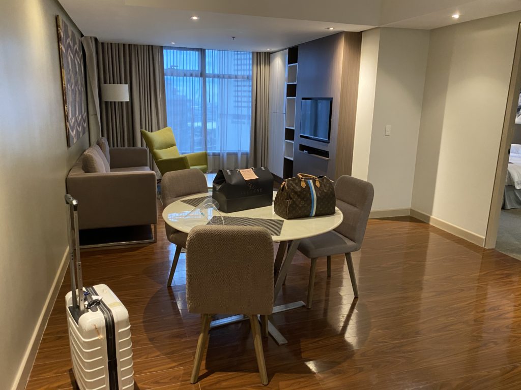 Modern living and dining area with neutral tones and city view.