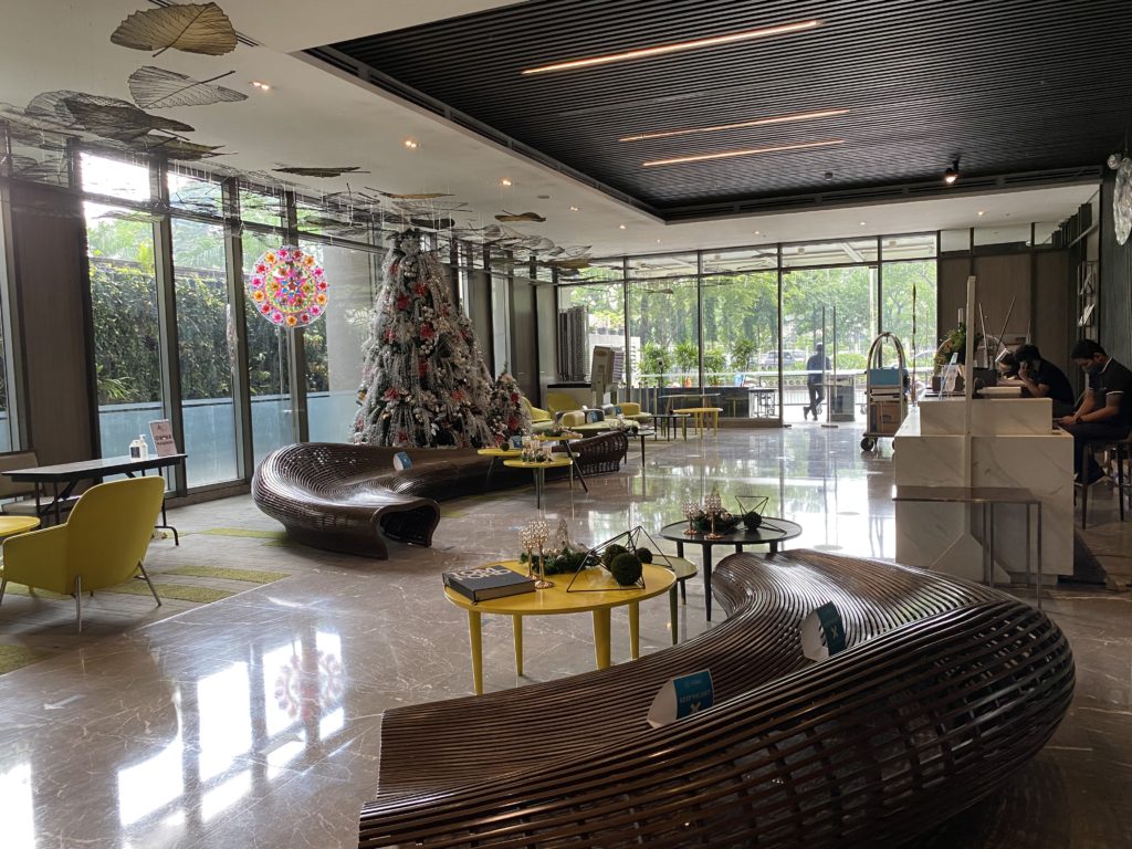 Modern hotel lobby with festive Christmas decor and large windows.