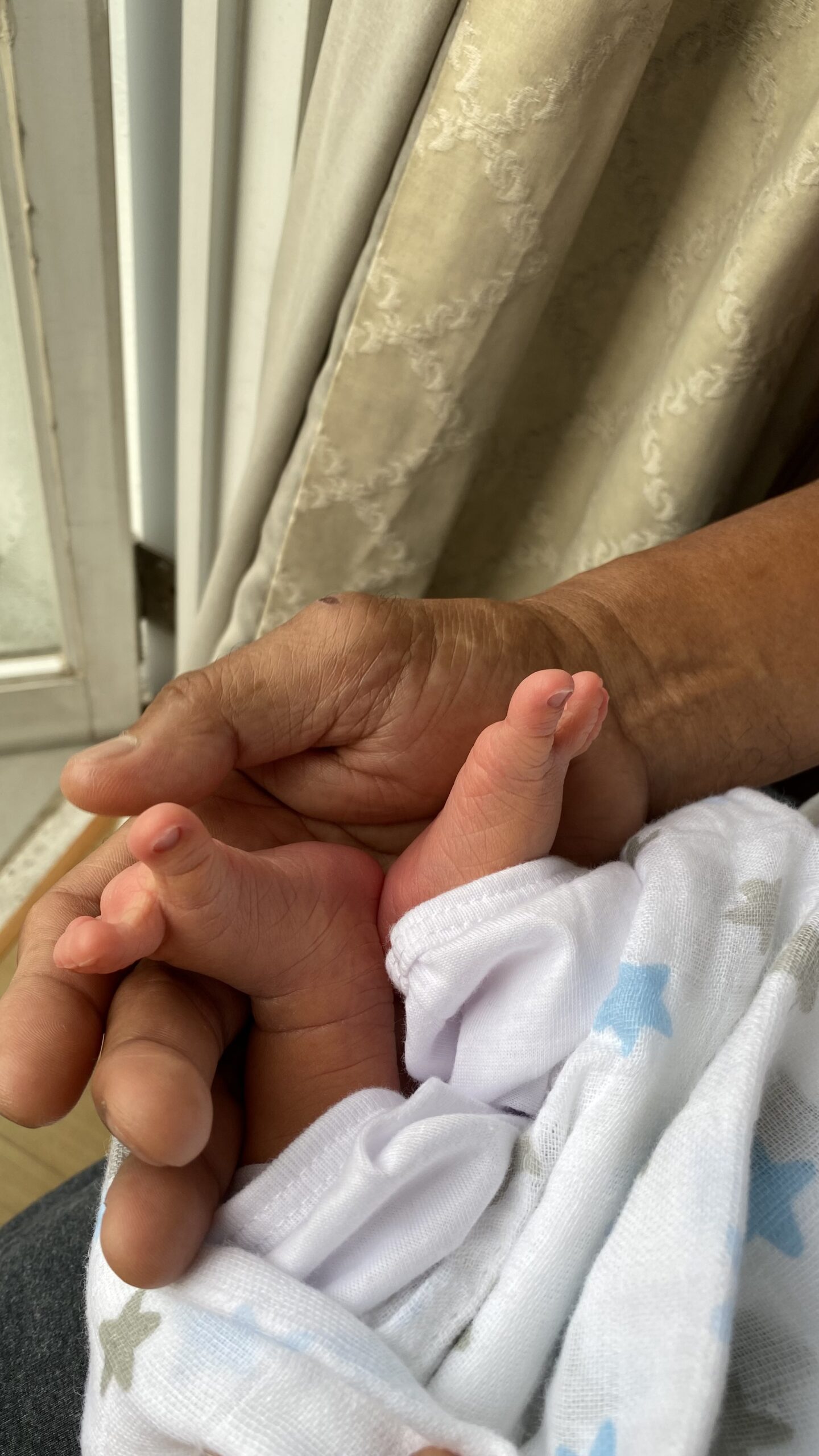 Lolo holds baby's tiny feet