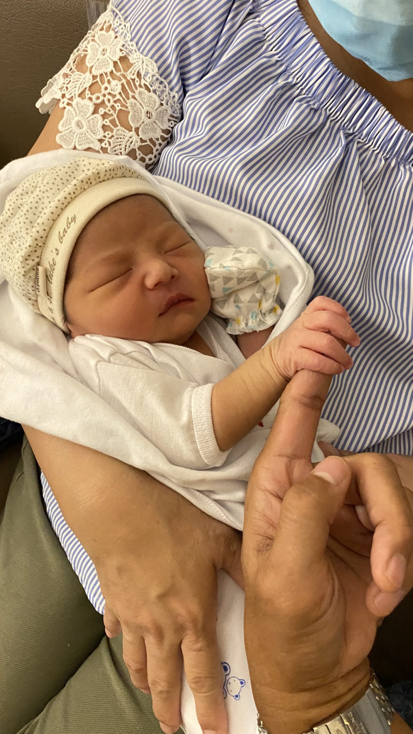 Baby holds lolo's finger