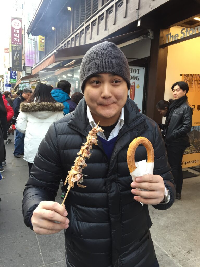 A person enjoying street food in a busy urban area.